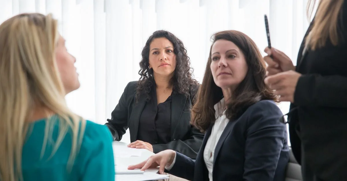 Femmes engagées dans une réunion d'affaires collaborative à l'intérieur avec de la lumière naturelle.