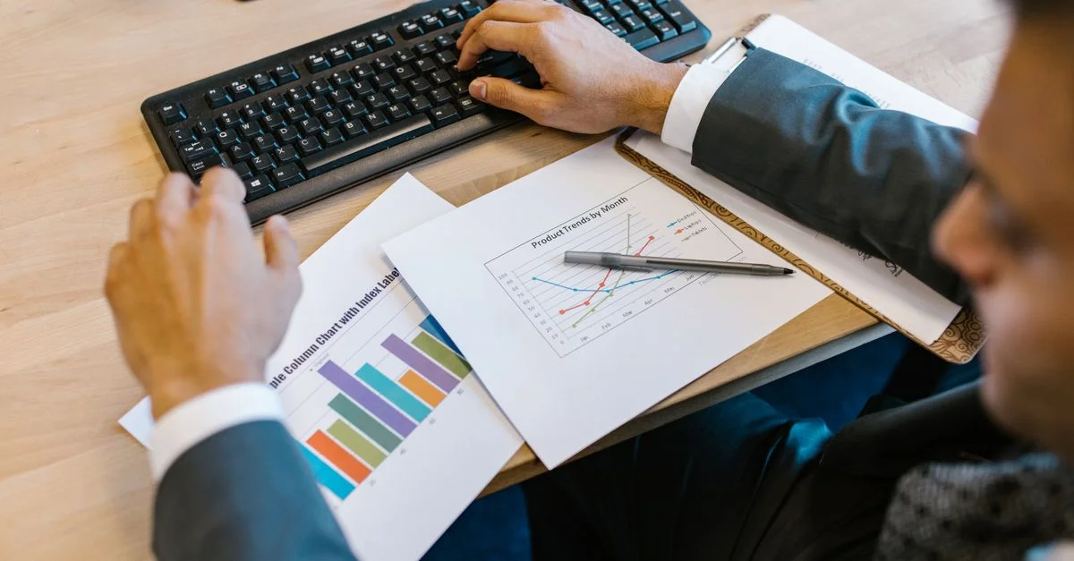 Professionnel d'affaires examinant des graphiques au bureau, analysant les tendances financières.